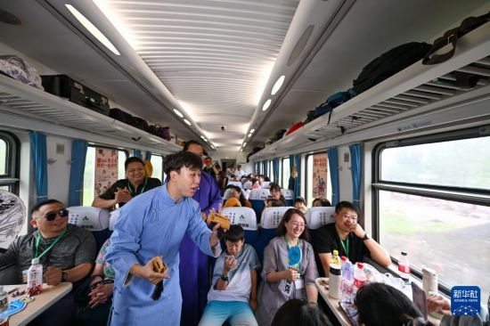 9月7日，相聲演員在S910列車(chē)上為旅客表演快板。