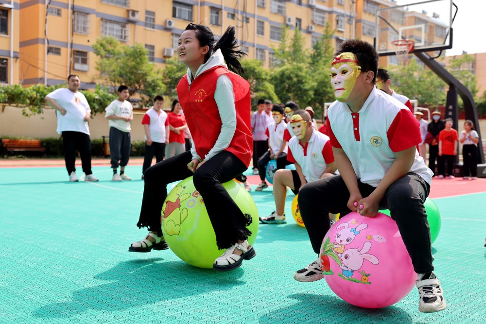 2024年5月17日，在山東省棗莊市市中區(qū)特殊教育中心，青年志愿者與智力障礙學(xué)生一起做游戲。新華社發(fā)（孫中喆攝）