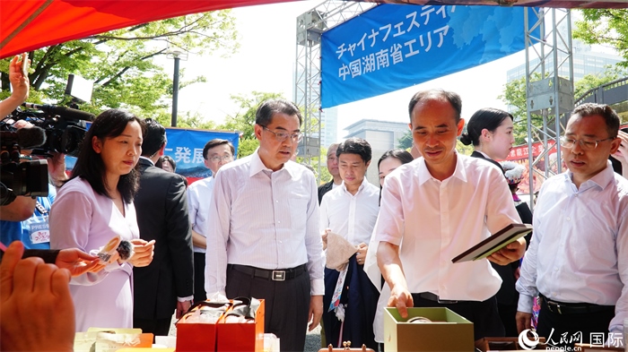 湖南展位工作人員向中國駐日本大使吳江浩介紹特色文創(chuàng)產品。人民網(wǎng) 蔣曉辰攝