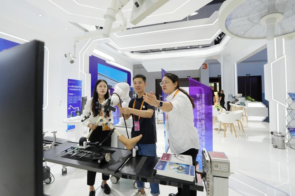 9月11日，一位媒體記者（中）在2024年服貿(mào)會(huì)國(guó)家會(huì)議中心會(huì)場(chǎng)體驗(yàn)北京納通科技集團(tuán)有限公司的膝關(guān)節(jié)置換手術(shù)機(jī)器人。新華社記者鞠煥宗 攝
