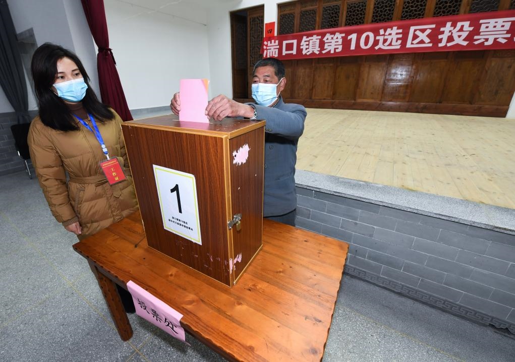 2021年12月14日，在浙江省杭州市臨安區(qū)湍口鎮(zhèn)迎豐村的基層投票點(diǎn)，村民在參加投票，村級監(jiān)察聯(lián)絡(luò)員監(jiān)票。新華社記者 徐昱 攝