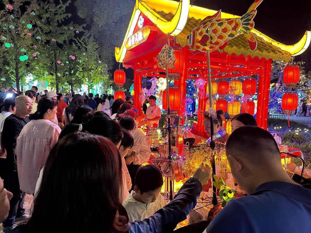 市民游客在2024年北京中秋國(guó)慶彩燈游園會(huì)上選購(gòu)特色文創(chuàng)商品。新華社記者楊淑君 攝