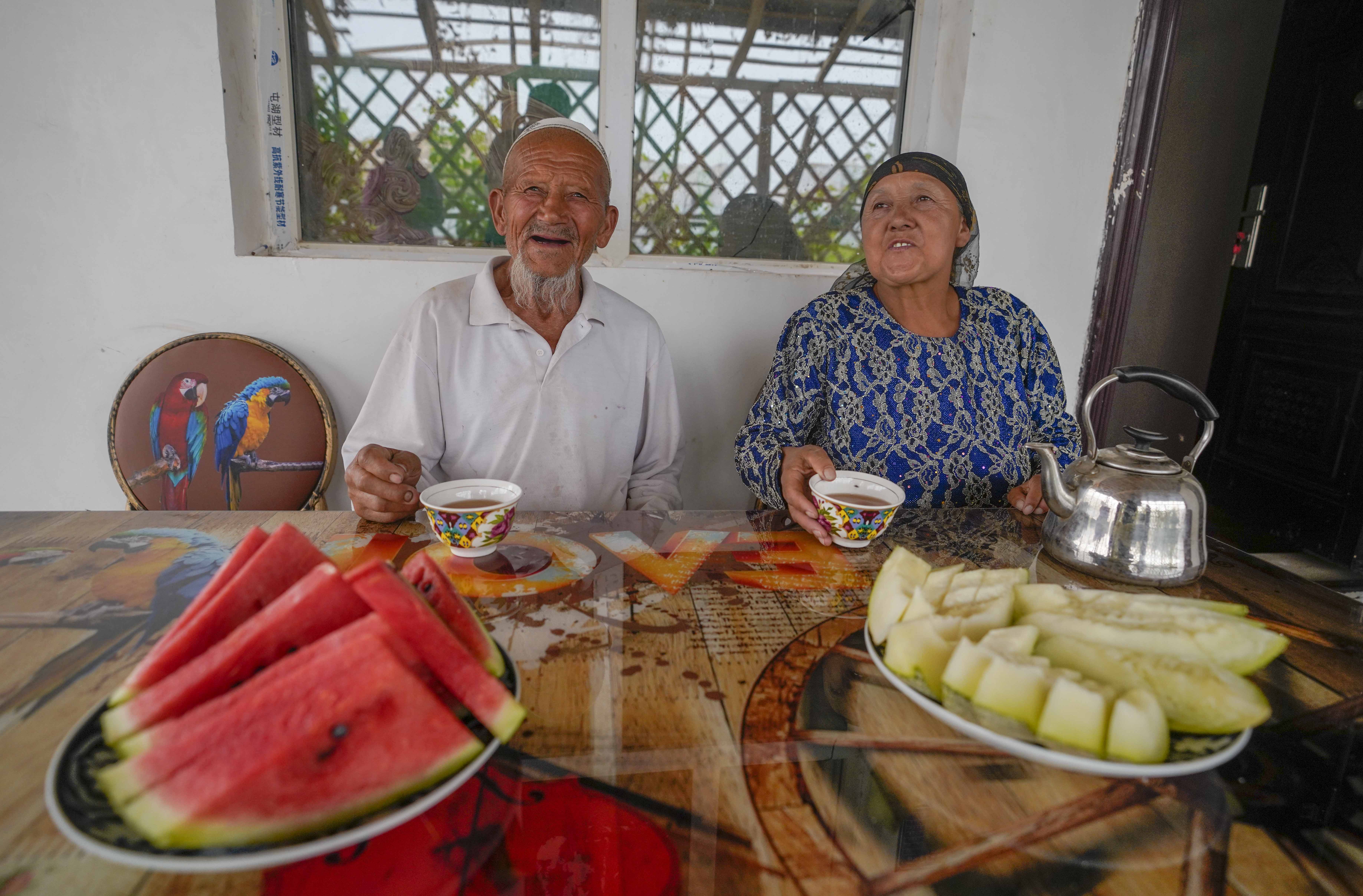 在新疆喀什地區(qū)伽師縣江巴孜鄉(xiāng)依帕克其村57號，80歲的維吾爾族老人伊米提·艾山（左）在自家庭院中（2020年6月8日攝）。