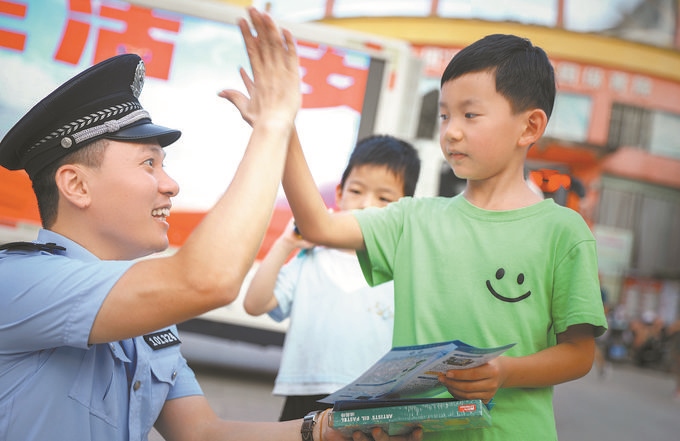▲7月10日，江西省吉安市公安局吉州分局組織民警深入轄區(qū)開展安全宣傳，民警向小朋友講解防溺水知識(shí)。朱文杰攝