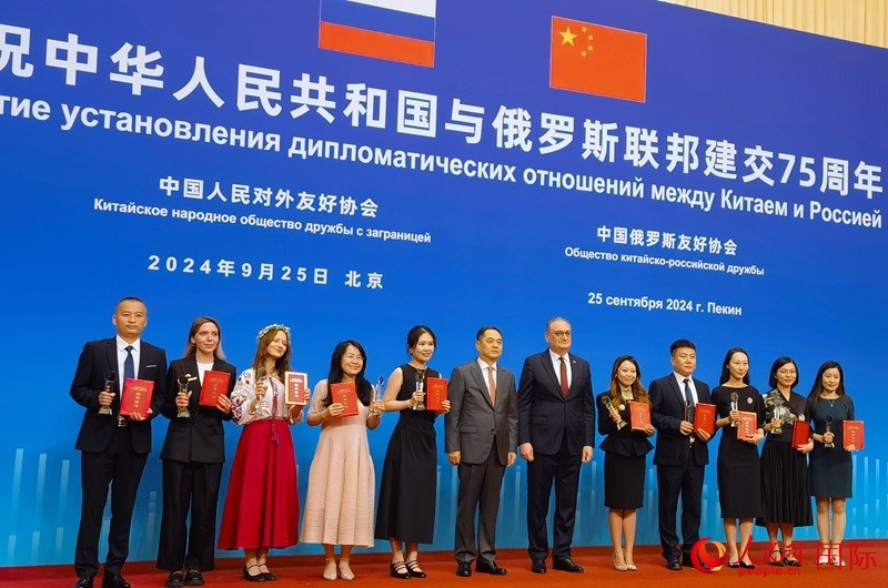 楊萬(wàn)明會(huì)長(zhǎng)和莫爾古洛夫大使為10位中俄青年友好微視頻創(chuàng)意大賽獲獎(jiǎng)代表頒獎(jiǎng)。人民網(wǎng)記者 李明琪攝