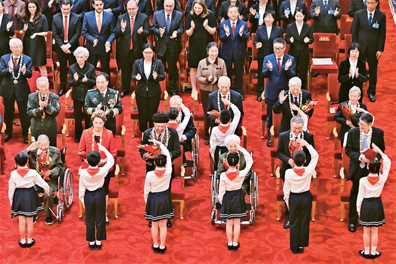 2024年9月29日，中華人民共和國(guó)國(guó)家勛章和國(guó)家榮譽(yù)稱(chēng)號(hào)頒授儀式在北京人民大會(huì)堂隆重舉行。圖為少先隊(duì)員向國(guó)家勛章和國(guó)家榮譽(yù)稱(chēng)號(hào)獲得者敬禮致意。 新華社記者 岳月偉/攝