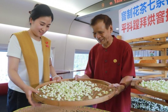 10月1日，福州市茉莉花茶窨制工藝代表性傳承人張子建與旅客在G1634次列車上制作茉莉花茶。新華社記者周義 攝