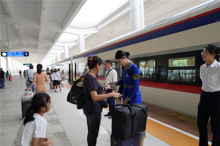 中老鐵路工作人員在站臺(tái)指引旅客進(jìn)站乘車。老中鐵路有限公司供圖