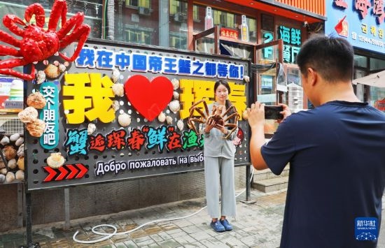 9月21日，游客在吉林省琿春市一處帝王蟹元素主題裝飾前拍照留念。新華社發(fā)
