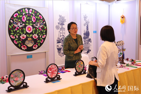 青海非遺文化傳承人向嘉賓介紹展品。人民網(wǎng)實(shí)習(xí)生姚欣可攝
