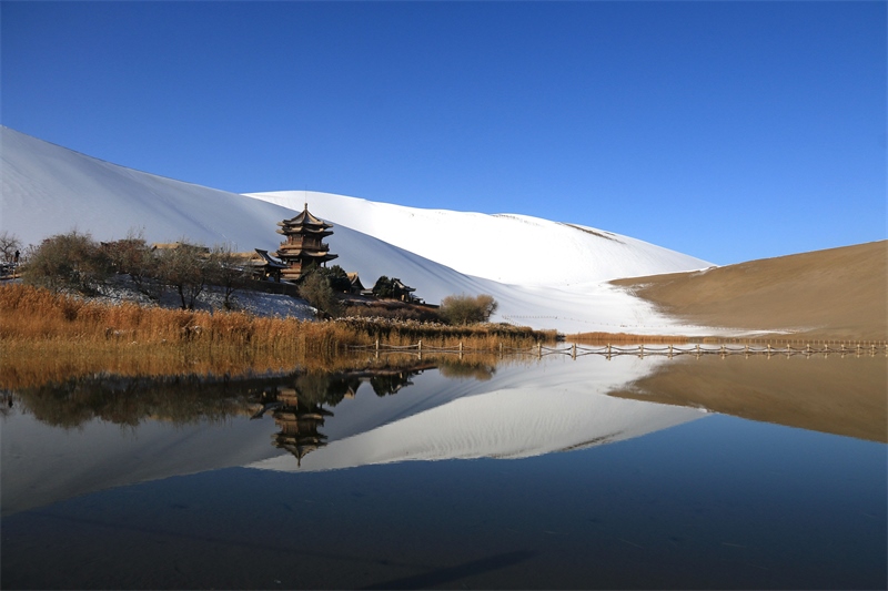 鳴沙山月牙泉景區(qū)雪景。敦煌市委宣傳部供圖，張曉亮攝