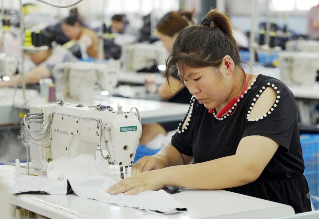 5月20日，村民在李寨村服裝加工廠內(nèi)忙碌。河南省周口市沈丘縣馮營鎮(zhèn)李寨村地處豫東平原。近年來，乘著脫貧攻堅(jiān)與鄉(xiāng)村振興政策的東風(fēng)，李寨村積極探索產(chǎn)業(yè)發(fā)展模式，通過“龍頭企業(yè)+村集體經(jīng)濟(jì)+農(nóng)戶”的方式，逐漸發(fā)展形成肉牛養(yǎng)殖、設(shè)施農(nóng)業(yè)、服裝加工、康養(yǎng)民宿等產(chǎn)業(yè)，以產(chǎn)業(yè)振興助力鄉(xiāng)村振興。新華社記者 李嘉南 攝