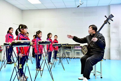 圖為12月30日，在惠民縣胡集鎮(zhèn)第一小學(xué)，老師指導(dǎo)學(xué)生學(xué)習(xí)西河大鼓。新華社記者 郭緒雷攝