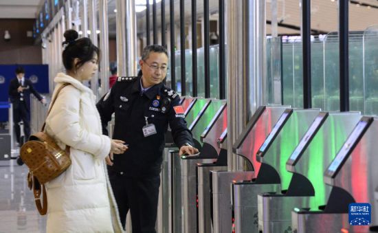 1月2日，大興機(jī)場邊檢站警察指導(dǎo)旅客使用自助出境設(shè)備。新華社記者 李欣 攝