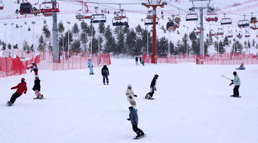 2025年1月8日，滑雪愛好者在新疆阿勒泰市將軍山滑雪場(chǎng)的雪道上滑行。新華社記者 張嘯誠(chéng) 攝