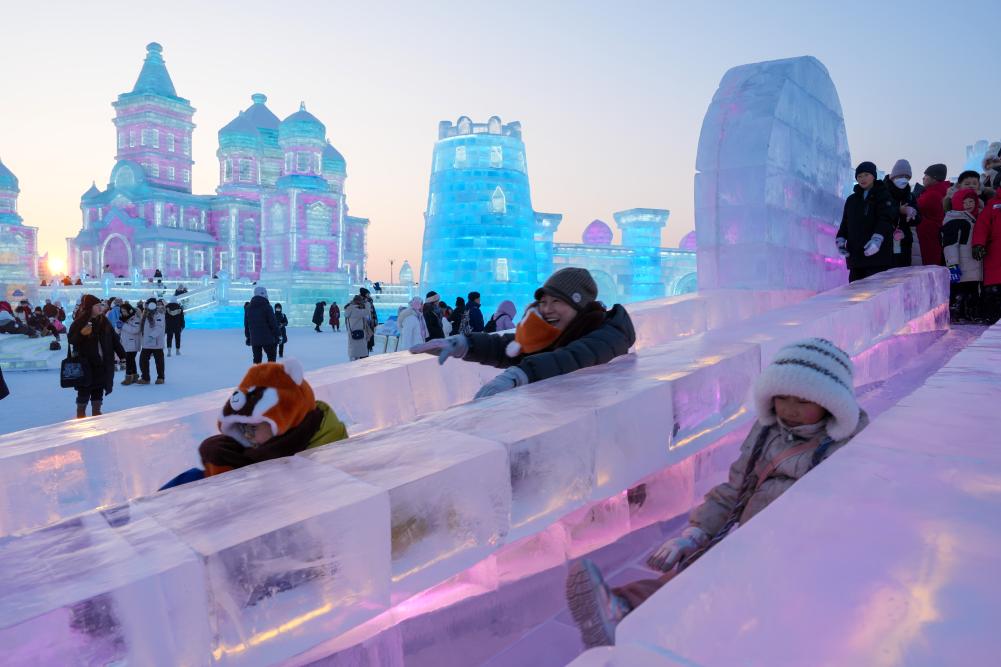 游客在哈爾濱冰雪大世界園區(qū)內體驗冰滑梯。新華社發(fā)