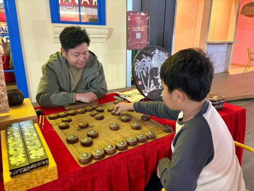 柯秋楓與市民下椰雕象棋。人民網 陳葉欣攝