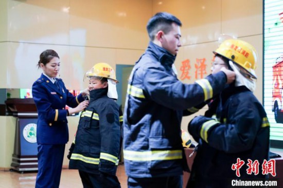 圖為學(xué)生們現(xiàn)場(chǎng)穿戴消防頭盔和戰(zhàn)斗服。中新社記者 趙宇航 攝
