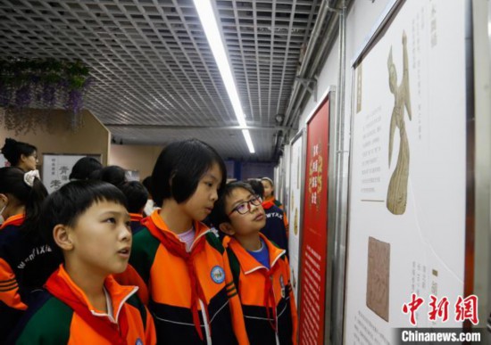 圖為學生參觀青海省博物館“1+3”主題流動展覽，了解木舞俑。中新社記者 馬銘言 攝