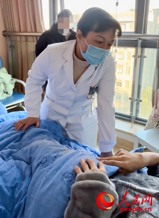 鄧茜查房時詢問患者情況。人民網(wǎng)記者 金慧慧攝