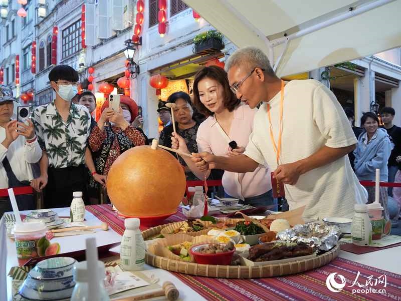 嘉賓品嘗海南傳統(tǒng)美食“煎堆”。人民網(wǎng)記者 張力洋攝