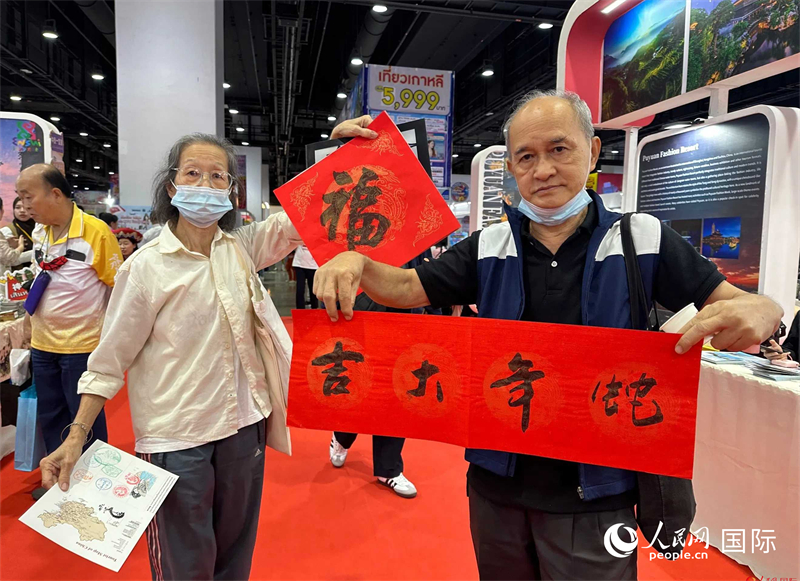 2025蛇年春節(jié)，泰國市民展示他們領到的華人手寫春聯(lián)。人民網記者 簡承淵攝