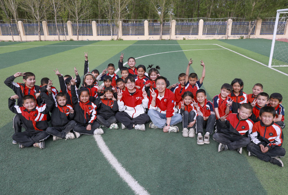 4月23日，在新疆克州阿圖什市哈拉峻鄉(xiāng)謝依特小學，支教教師王俊文（中左）、李軻凡（中右）和學生在一起。