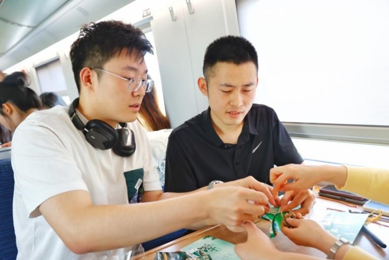 G232次旅客親手制作端午荷包和五彩繩。王磊攝