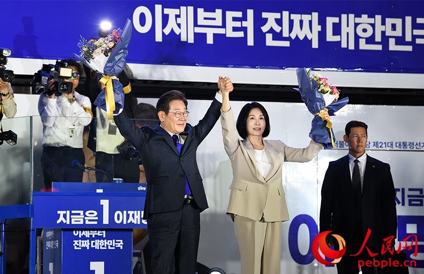 6月4日凌晨，確定當(dāng)選韓國總統(tǒng)的李在明舉手向歡呼的支持者們致意。 人民網(wǎng) 康炯彬攝